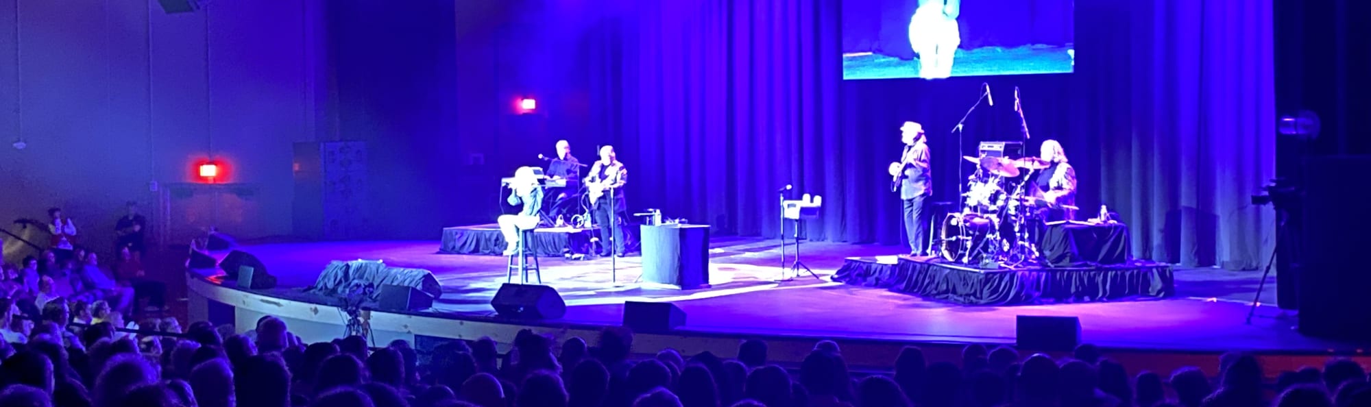 signer on stage in chair washed out by the lights Tulsa